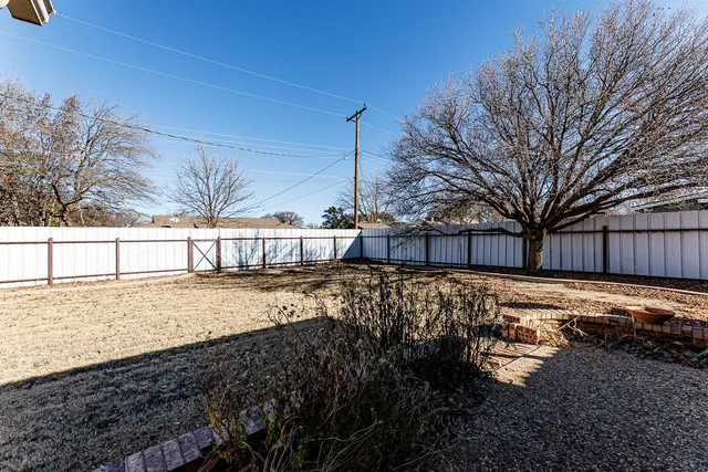 a view of a yard with wooden fence