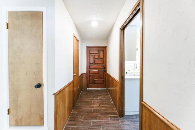 a view of a hallway with wooden floor and staircase