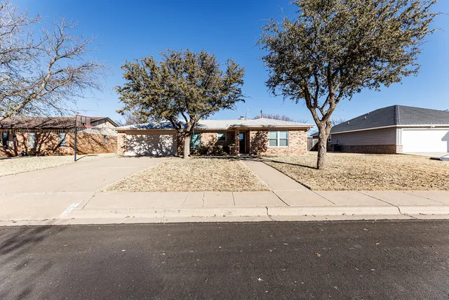 a white house that has a tree in front of it