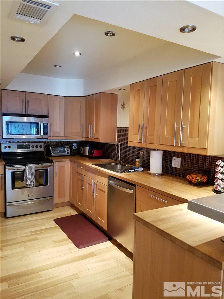 1316 Jones Street Reno, NV 89503 - Photo 4 of 16 a kitchen with stainless steel appliances granite countertop a stove a sink and a microwave