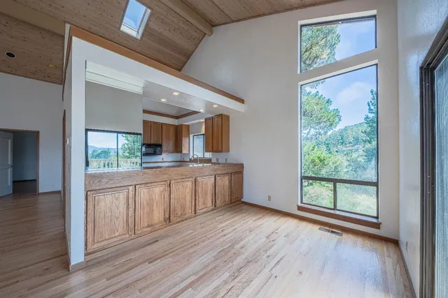 a kitchen with stainless steel appliances wooden floors and large window