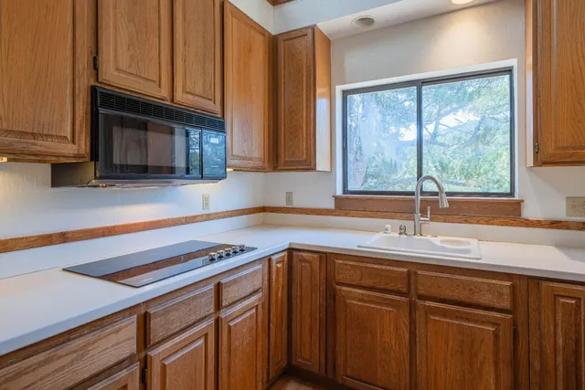 a kitchen with stainless steel appliances granite countertop a sink a stove and cabinets