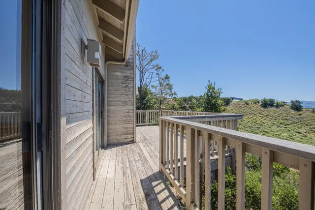 a view of balcony with wooden floor and fence