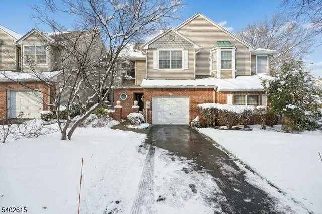 a front view of a house with a yard covered in snow