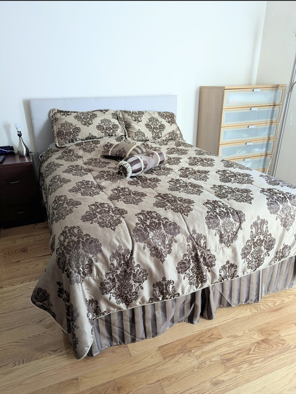 99 Pond Avenue, Unit 409 Brookline, MA 02445 - Photo 13 of 28 a bed sitting in a bedroom next to a large mirror