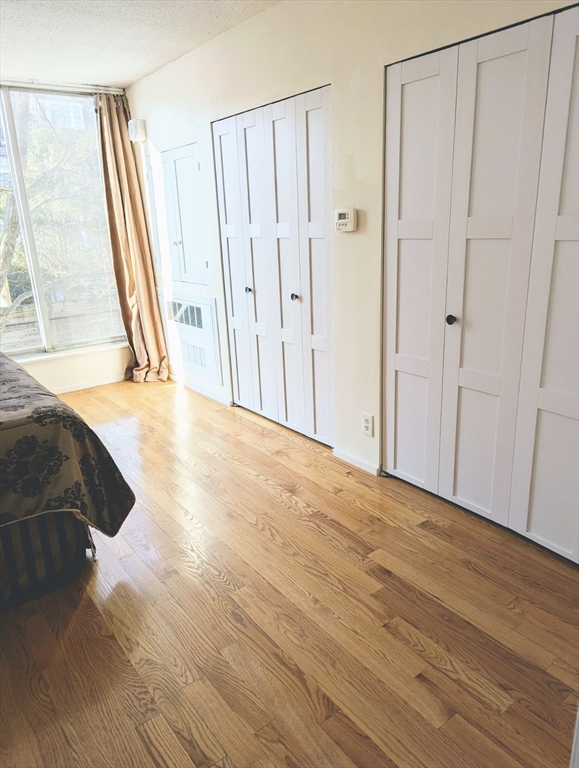 99 Pond Avenue, Unit 409 Brookline, MA 02445 - Photo 15 of 28 a view of a room with wooden floor and a window
