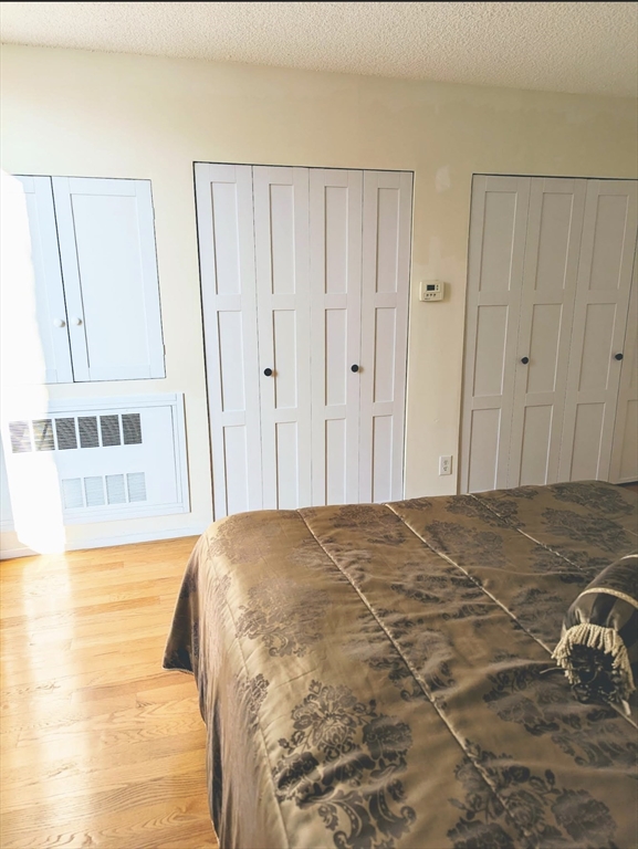 99 Pond Avenue, Unit 409 Brookline, MA 02445 - Photo 16 of 28 a bedroom with a bed and a mirror