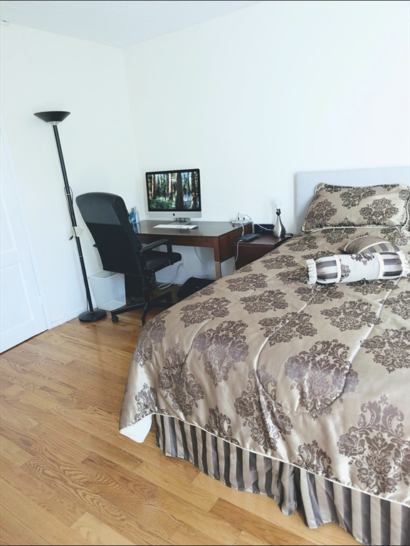99 Pond Avenue, Unit 409 Brookline, MA 02445 - Photo 18 of 28 a bedroom with a bed a couch and chair