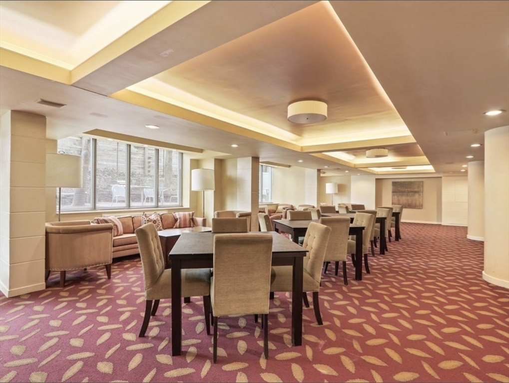99 Pond Avenue, Unit 409 Brookline, MA 02445 - Photo 23 of 28 a dining hall with lots of tables a large window and a rug