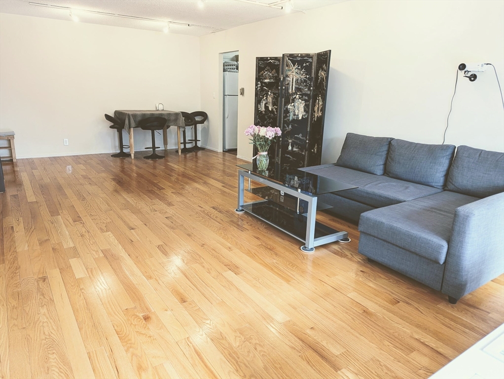 99 Pond Avenue, Unit 409 Brookline, MA 02445 - Photo 8 of 28 a living room with furniture and a table