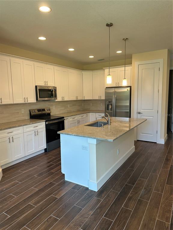 4011 Amber Road Valrico, FL 33594 - Photo 28 of 32 a kitchen with kitchen island granite countertop a sink counter top space and stainless steel appliances