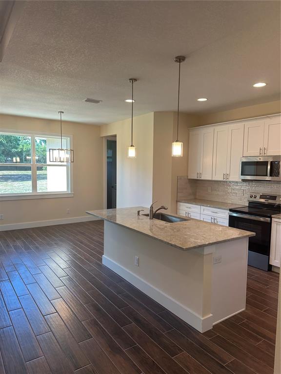 4011 Amber Road Valrico, FL 33594 - Photo 29 of 32 a kitchen with stainless steel appliances granite countertop a sink a stove and a wooden floors