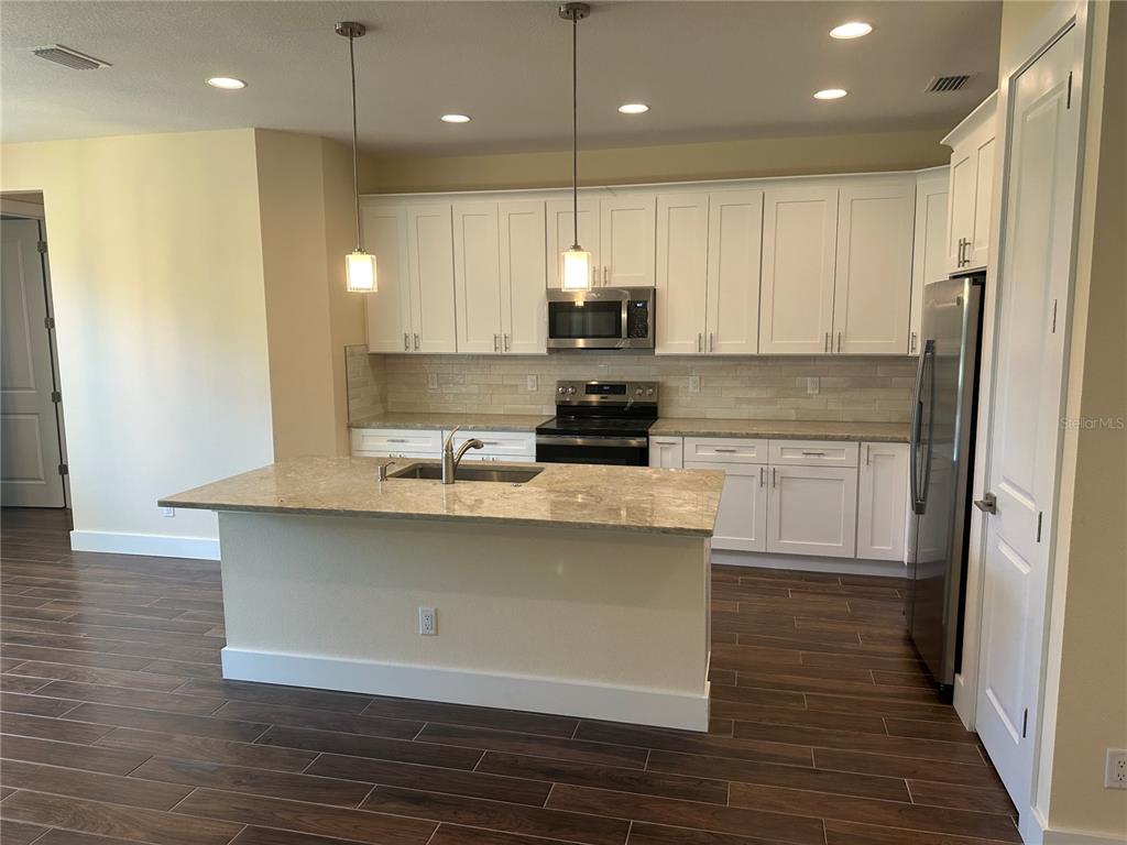 4011 Amber Road Valrico, FL 33594 - Photo 7 of 32 a kitchen with stainless steel appliances granite countertop a sink a stove and a refrigerator