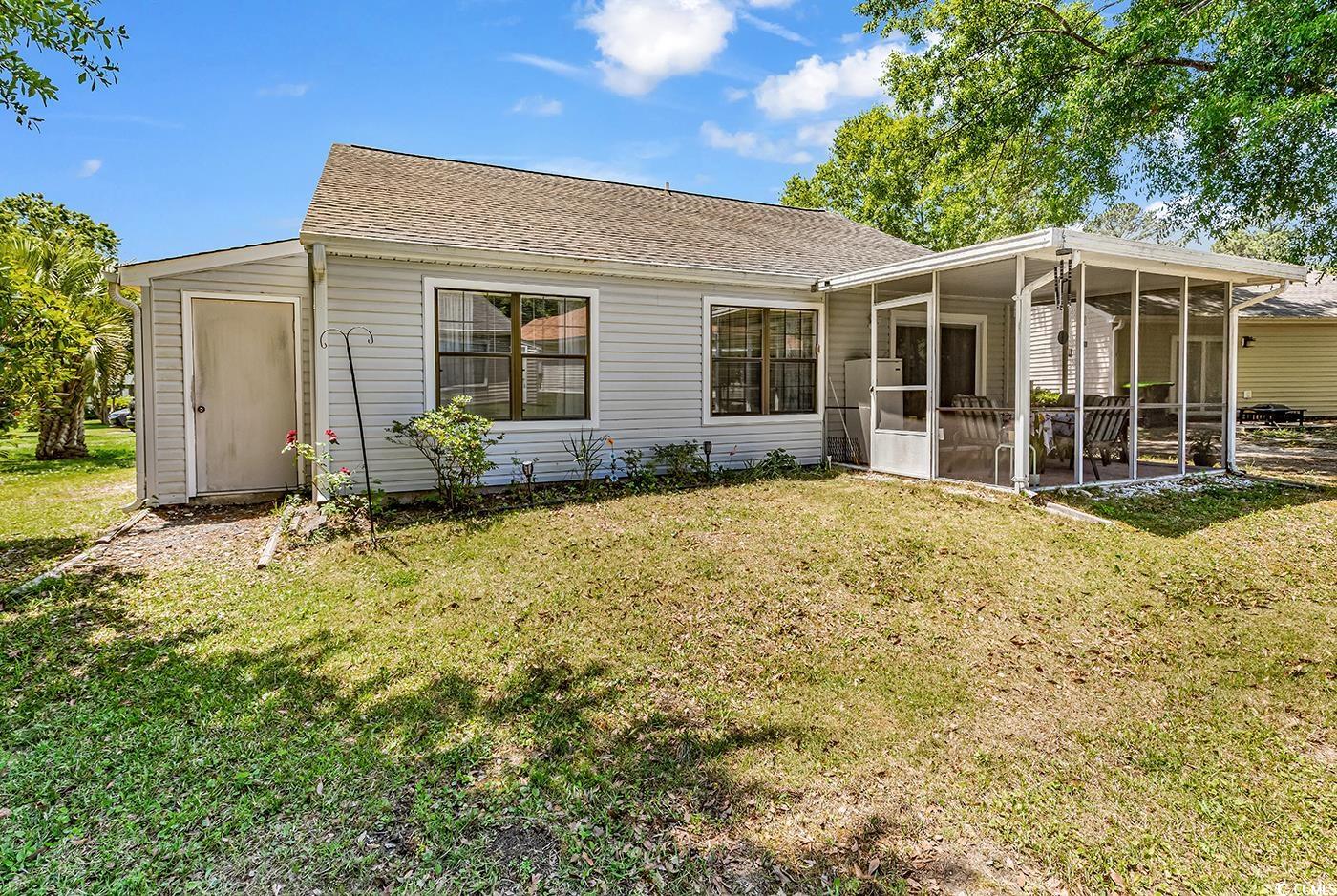 6628 Mallard View Point Myrtle Beach, SC 29588 - Photo 25 of 34 Back of property featuring a yard, a shingled roof, and a sunroom