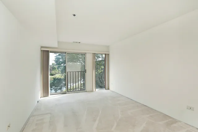 a view of a big room with wooden floor and windows