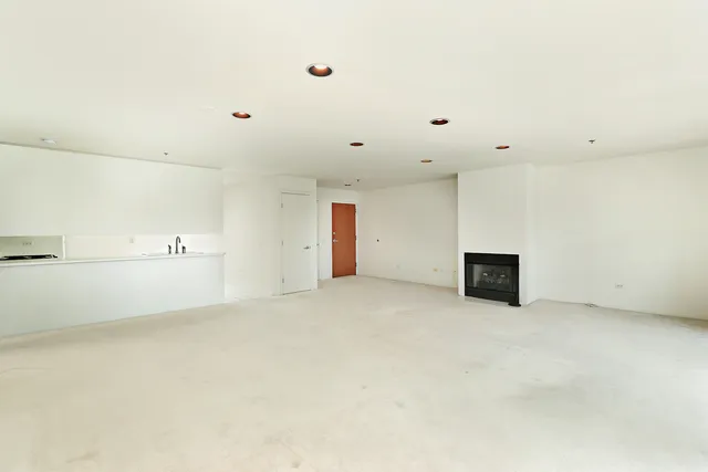 a view of an empty room with kitchen