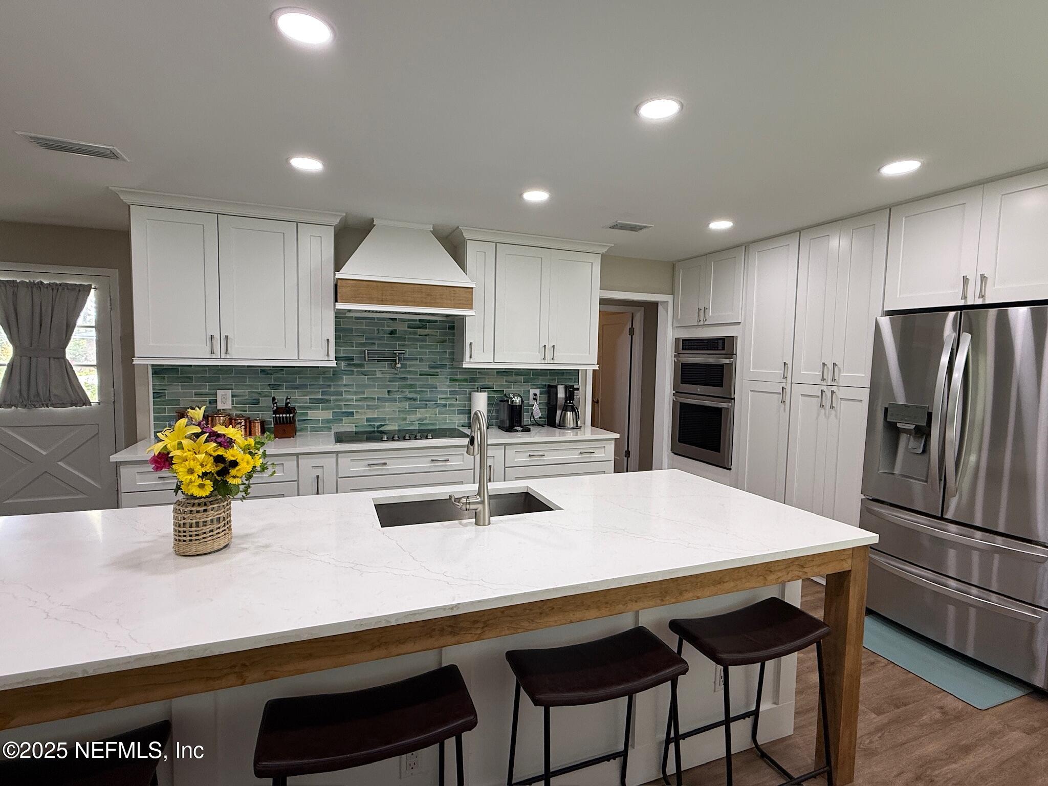 716 Oak Street Neptune Beach, FL 32266 - Photo 4 of 23 a kitchen with refrigerator and chairs