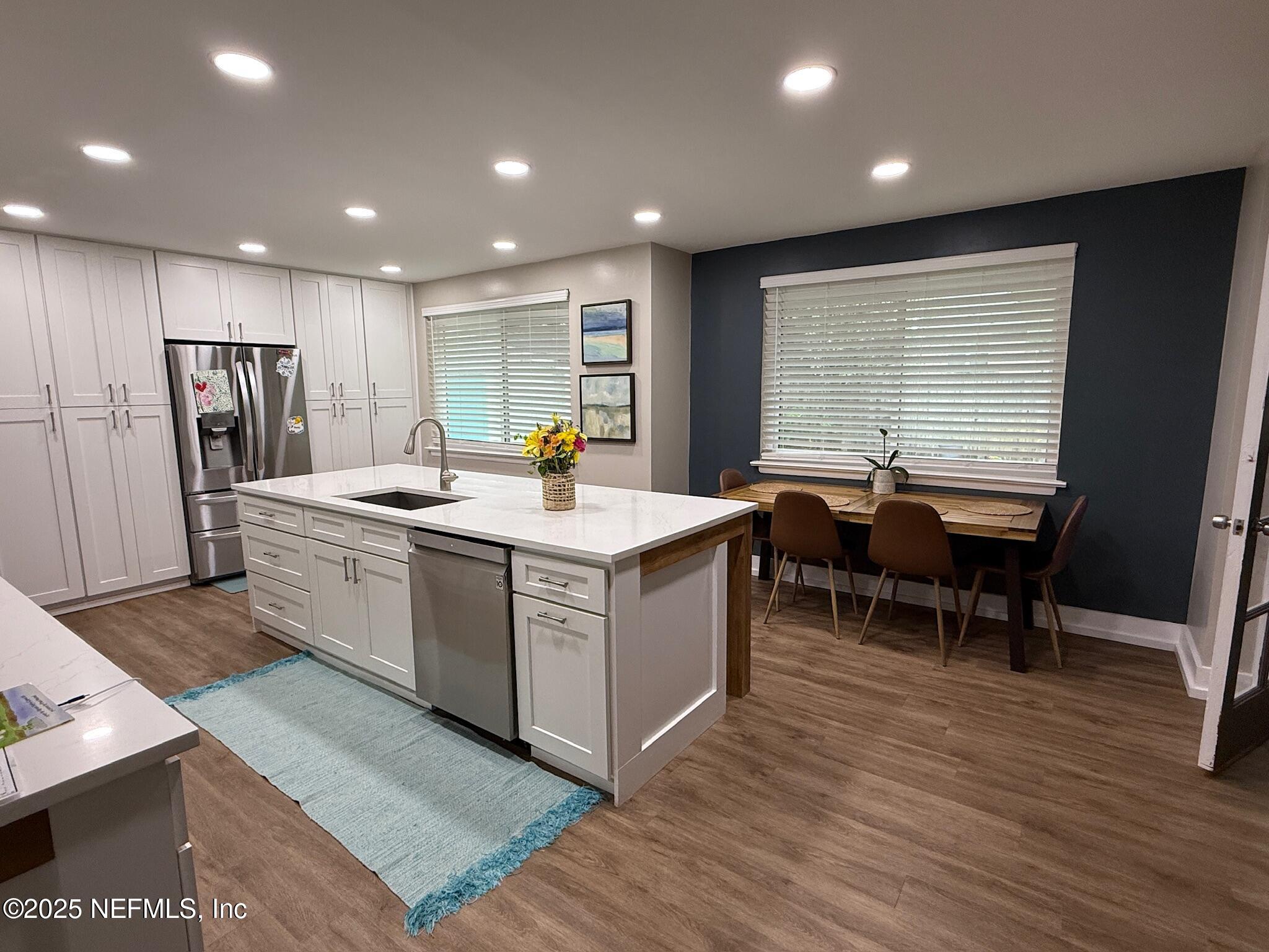 716 Oak Street Neptune Beach, FL 32266 - Photo 6 of 23 a view of open kitchen with wooden floor and chairs
