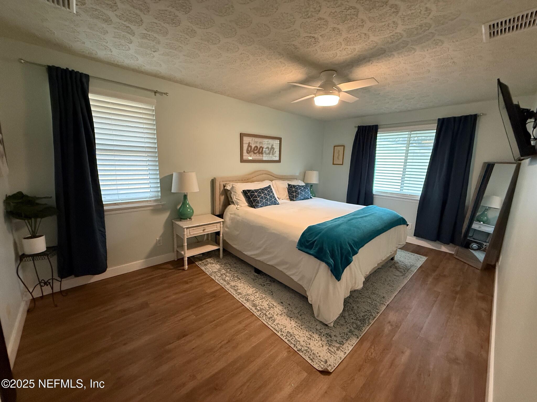716 Oak Street Neptune Beach, FL 32266 - Photo 10 of 23 a bedroom with a bed and a flat tv screen on dresser
