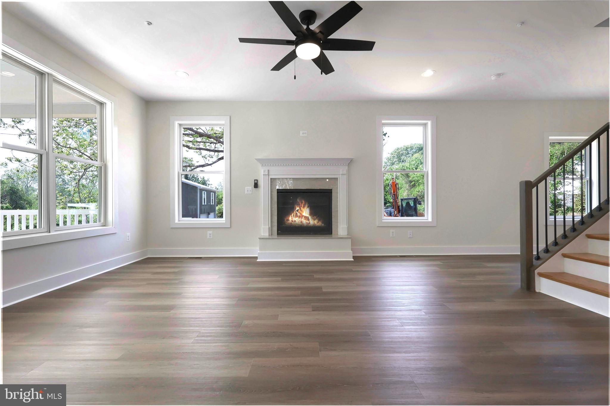 23131 Meadow Road Bushwood, MD 20618 - Photo 30 of 42 a view of an empty room with wooden floor fireplace and a window