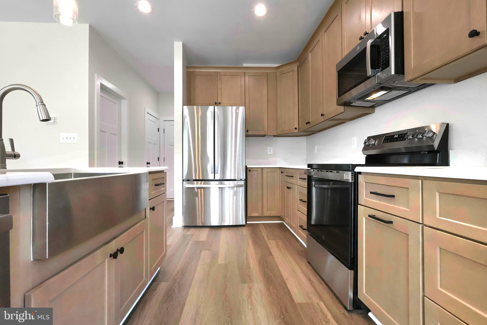 23131 Meadow Road Bushwood, MD 20618 - Photo 10 of 42 a kitchen with a sink a microwave a refrigerator and cabinets