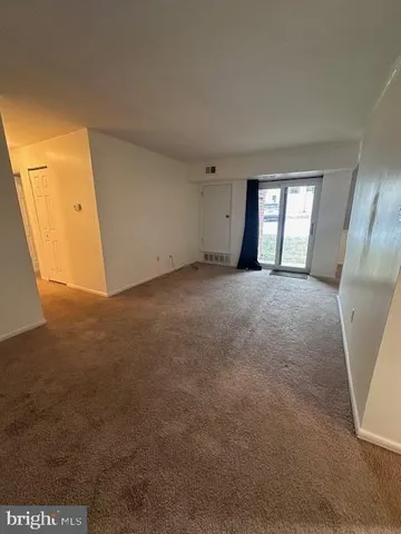 a view of an empty room with a fireplace and a window