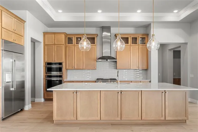 a kitchen with kitchen island granite countertop a refrigerator and a sink