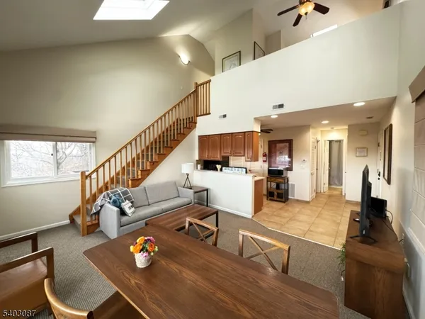 a living room with furniture kitchen view and a large window