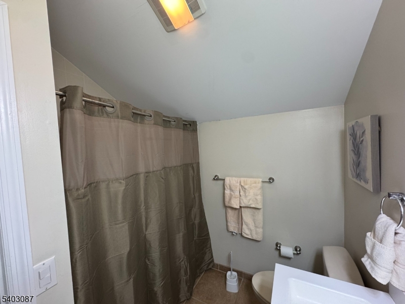 3 Telemark Drive, Unit 12 Vernon, NJ 07462 - Photo 12 of 14 a bathroom with a shower curtain and a toilet
