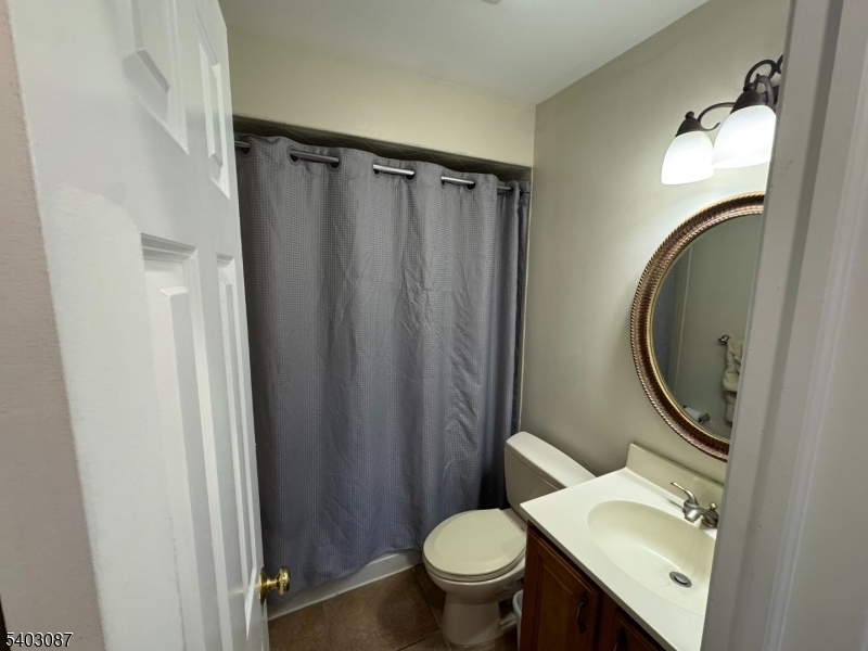 3 Telemark Drive, Unit 12 Vernon, NJ 07462 - Photo 13 of 14 a bathroom with a sink a toilet a mirror and shower curtain