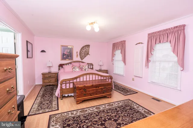 a bedroom with a bed rug and dresser