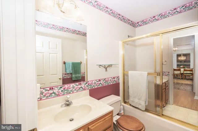 a bathroom with a sink and mirror with toilet