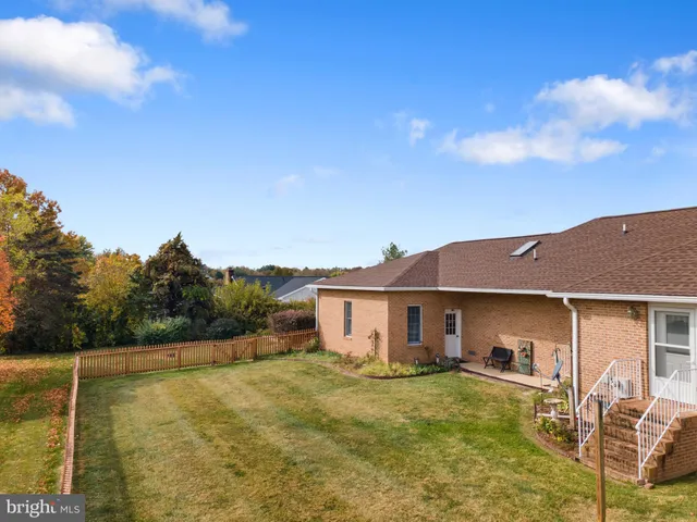 a view of a house with backyard and a tree