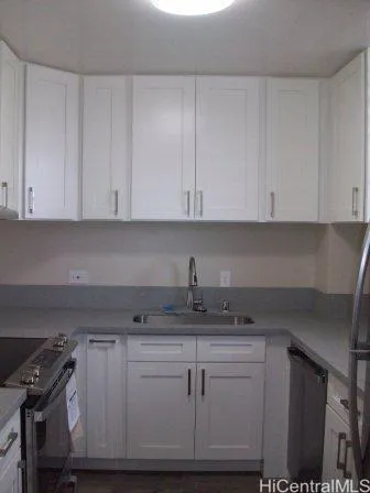 a kitchen with granite countertop white cabinets and a stove