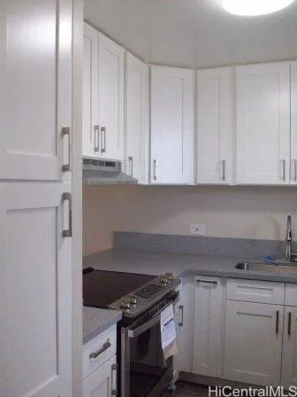 a kitchen with granite countertop white cabinets and stainless steel appliances