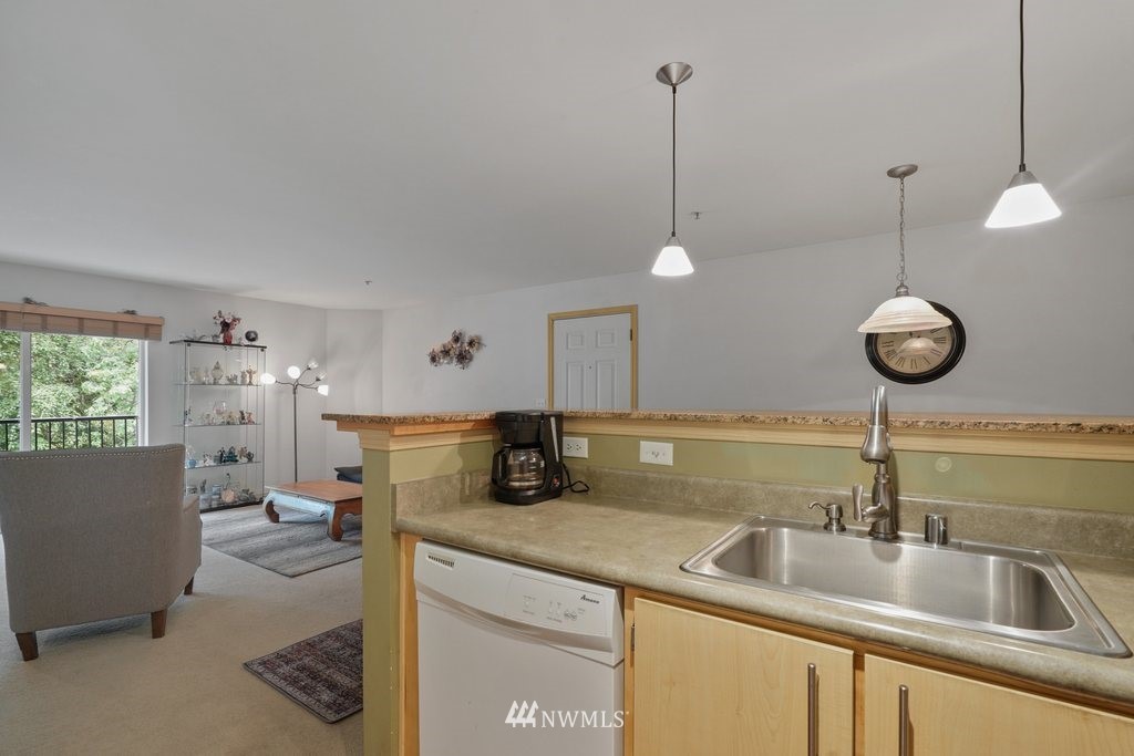 10709 Valley View Road, Unit A105 Bothell, WA 98011 - Photo 13 of 26 a kitchen with a sink a counter space appliances and cabinets