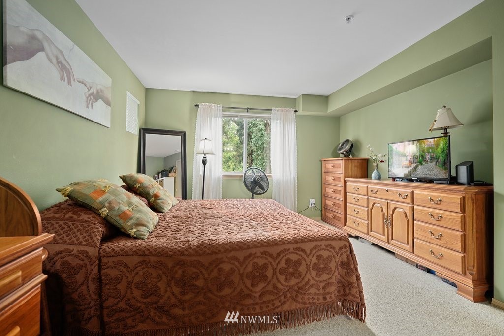 10709 Valley View Road, Unit A105 Bothell, WA 98011 - Photo 16 of 26 a bedroom with a bed and a dresser