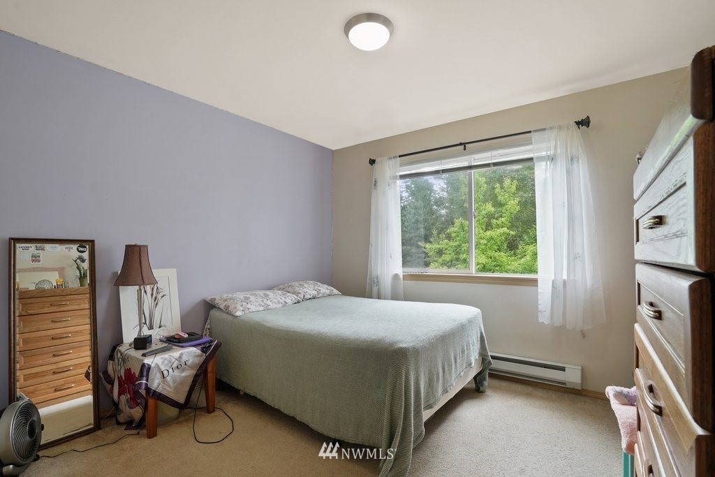 10709 Valley View Road, Unit A105 Bothell, WA 98011 - Photo 20 of 26 a bed sitting in a bedroom next to a window