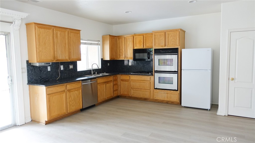 1415 Sunflower Way Perris, CA 92571 - Photo 11 of 39 a kitchen with stainless steel appliances granite countertop a stove a sink and a refrigerator