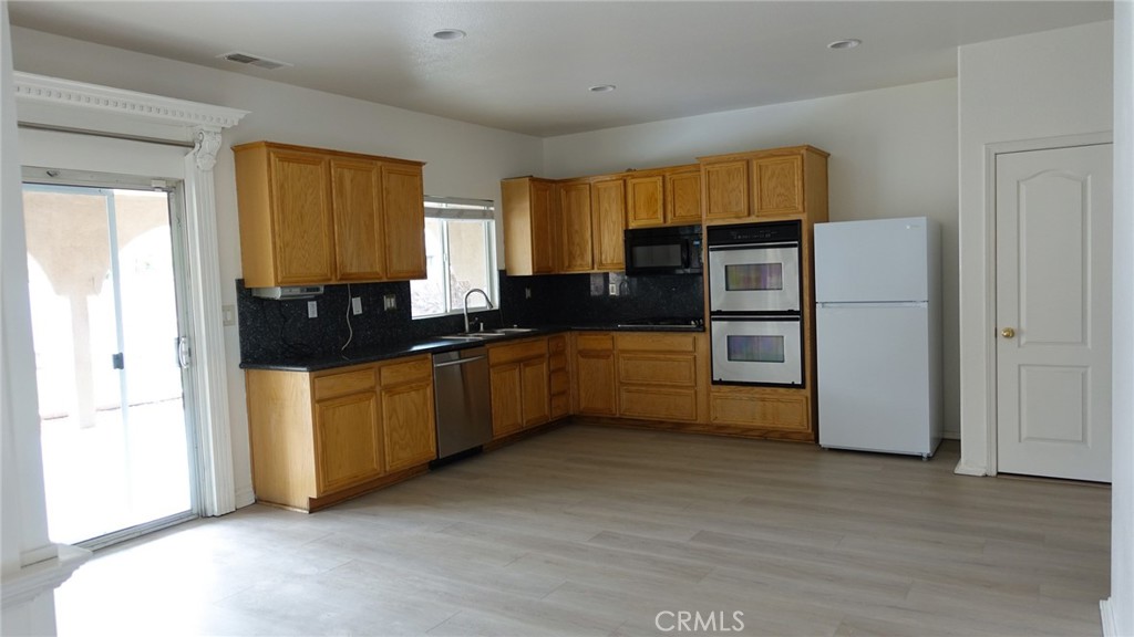 1415 Sunflower Way Perris, CA 92571 - Photo 12 of 39 a kitchen with stainless steel appliances a refrigerator sink and cabinets