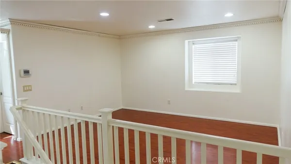 a view of a room with wooden floor and windows
