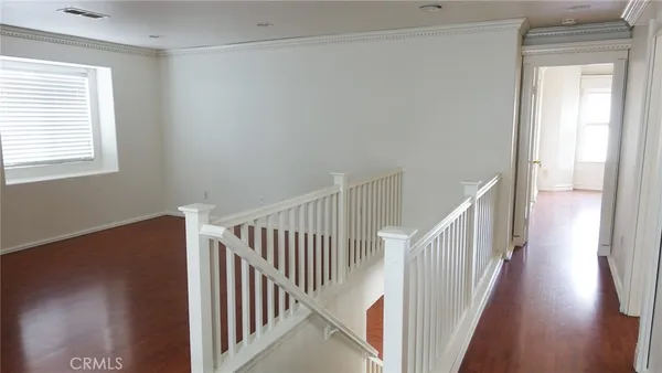 a view of a hallway with wooden floor and entryway