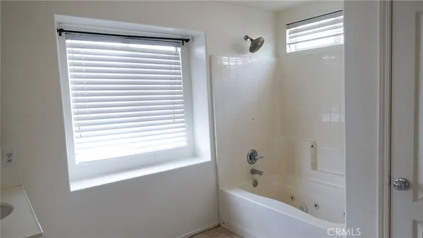 a bathroom with a bathtub next to a window