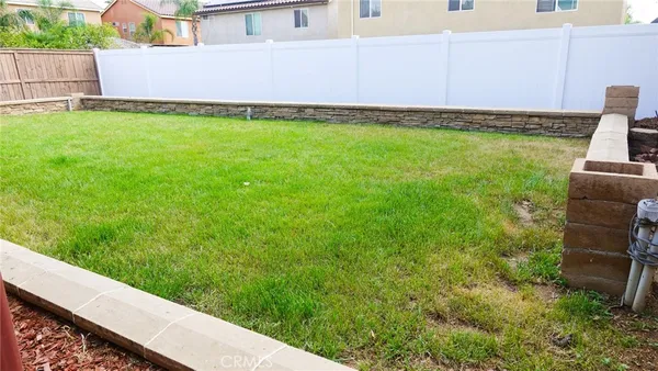 a view of a backyard with plants and wooden fence