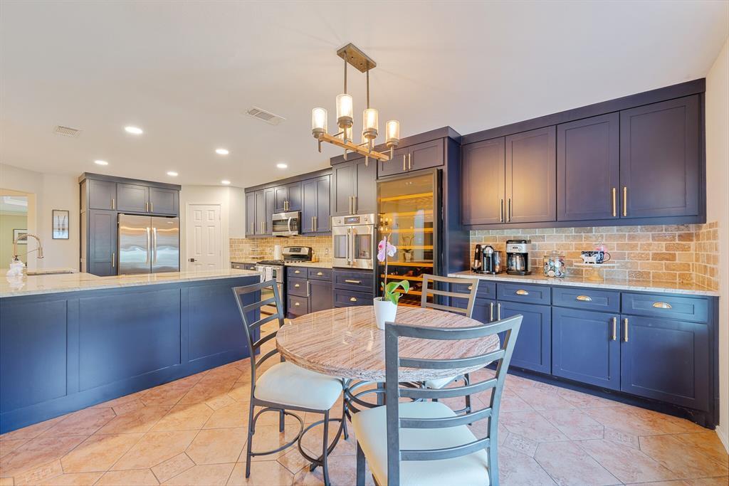 a kitchen with granite countertop wooden cabinets dining table and chairs