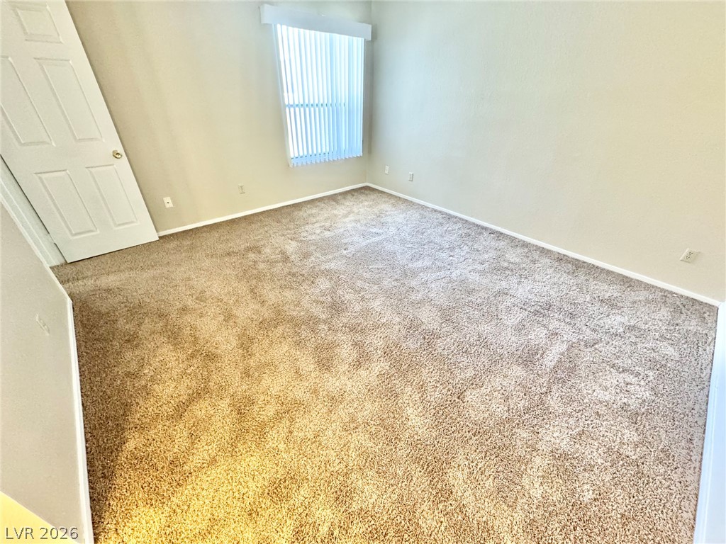 6250 West Flamingo Road, Unit 109 Las Vegas, NV 89103 - Photo 9 of 18 A well-lit, neutral-toned room features soft carpet and a clean, uncluttered aesthetic.
