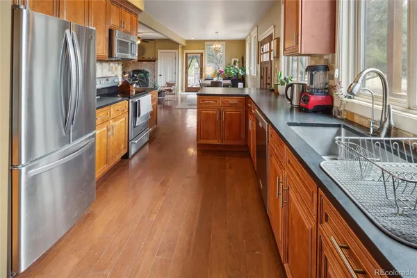 a kitchen with stainless steel appliances granite countertop lots of counter top space and wooden floor