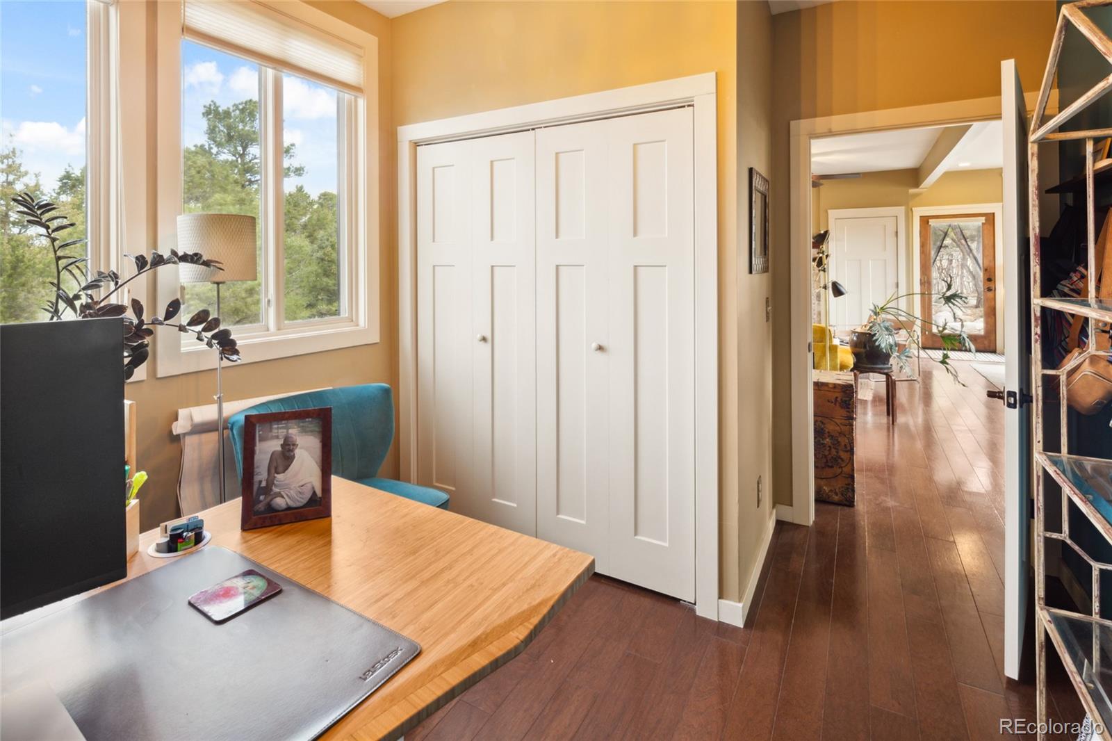 147 Moonlight Way Crestone, CO 81131 - Photo 17 of 47 a view of a hallway to a livingroom with furniture wooden floor and windows