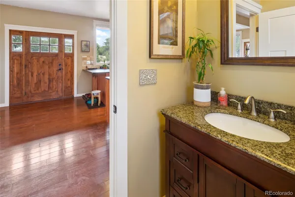 a bathroom with a granite countertop sink mirror and a toilet