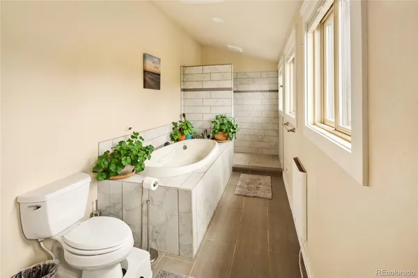 a spacious bathroom with a tub sink and mirror